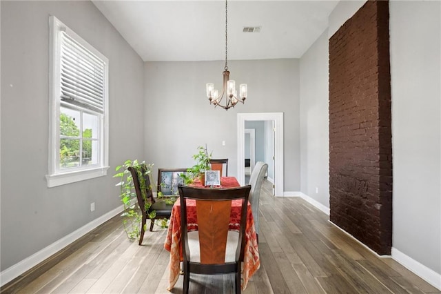 5530 Dauphine St, New Orleans, LA 70117 - dining area with a chandelier, wood-type flooring, and baseboards