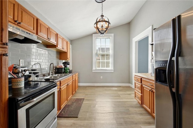 5530 Dauphine St, New Orleans, LA 70117 - kitchen featuring appliances with stainless steel finishes, a sink, under cabinet range hood, lofted ceiling, and light wood-style floors