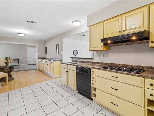 4536 Jasper St, Metairie, LA 70006 - kitchen with dishwasher, under cabinet range hood, cream cabinetry, gas cooktop, and dark countertops