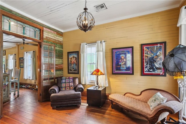 518 Pacific Ave, New Orleans, LA 70114 - sitting room featuring hardwood / wood-style flooring, a chandelier, wood walls, and ornamental molding