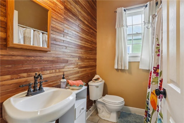 518 Pacific Ave, New Orleans, LA 70114 - full bathroom with wood walls, a sink, toilet, baseboards, and tile patterned flooring