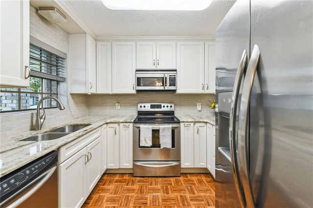 5304 Cross Creek Dr, Marrero, LA 70072 - kitchen featuring stainless steel appliances, a sink, white cabinets, a textured ceiling, and tasteful backsplash