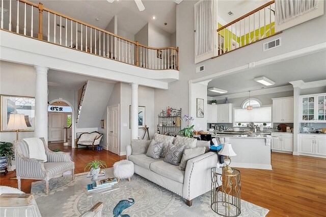 279 Debbie Dr, Slidell, LA 70458 - living room featuring a towering ceiling, wood finished floors, healthy amount of natural light, decorative columns, and recessed lighting