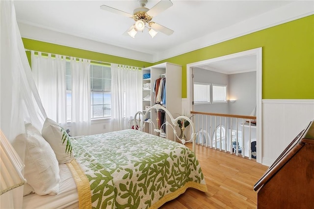 279 Debbie Dr, Slidell, LA 70458 - bedroom with wainscoting, multiple windows, wood finished floors, crown molding, and ceiling fan