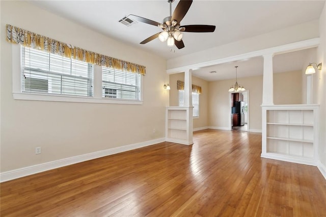 2609 General Pershing St, New Orleans, LA 70115 - spare room featuring wood-type flooring, baseboards, a ceiling fan, a chandelier, and decorative columns