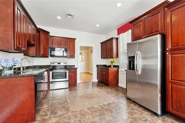 2609 General Pershing St, New Orleans, LA 70115 - kitchen with stainless steel appliances, a sink, recessed lighting, dark stone countertops, and baseboards