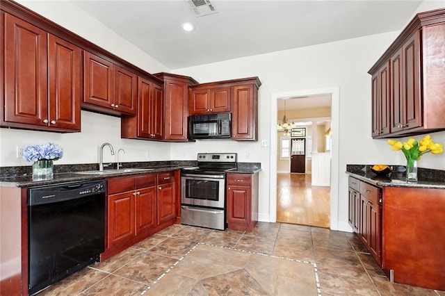2609 General Pershing St, New Orleans, LA 70115 - kitchen with black appliances, a sink, reddish brown cabinets, a chandelier, and dark stone countertops