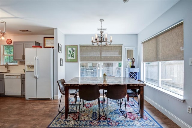 70046 9th St, Covington, LA 70433 - dining room with a chandelier, dark wood-style flooring, and baseboards