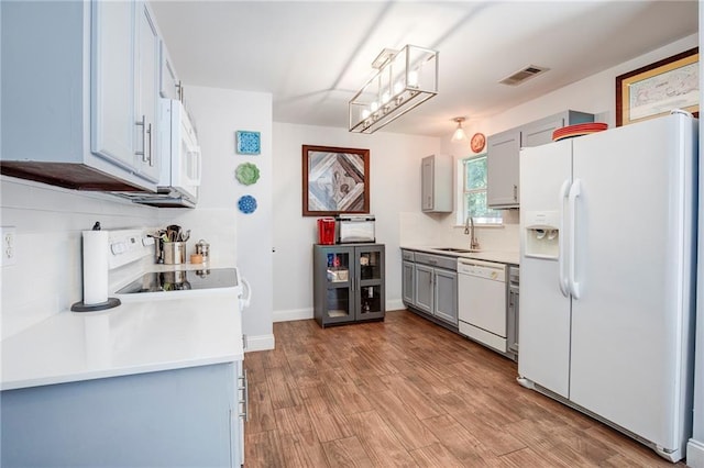 70046 9th St, Covington, LA 70433 - kitchen featuring white appliances, a sink, gray cabinets, light countertops, and light wood-type flooring