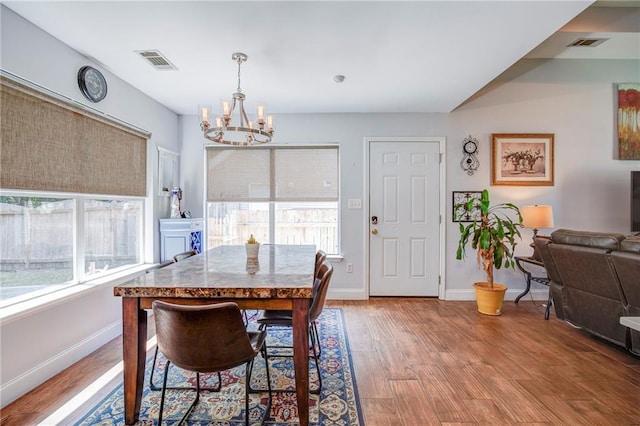 70046 9th St, Covington, LA 70433 - dining room featuring a chandelier, light wood-type flooring, and baseboards