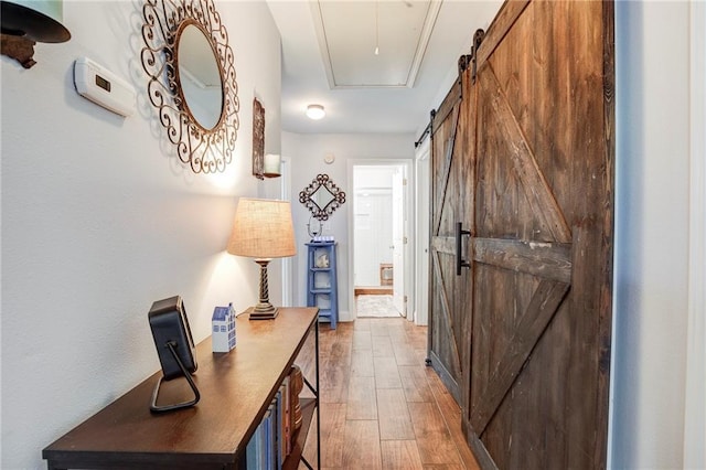 70046 9th St, Covington, LA 70433 - corridor featuring a barn door and light wood-style floors