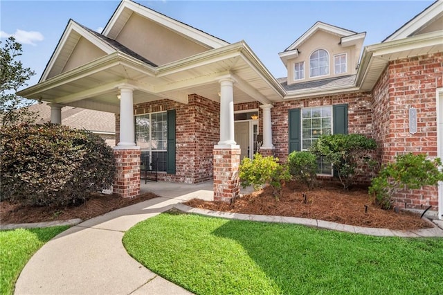 526 Moore Blvd, Covington, LA 70433 - doorway to property with brick siding, a porch, and a lawn