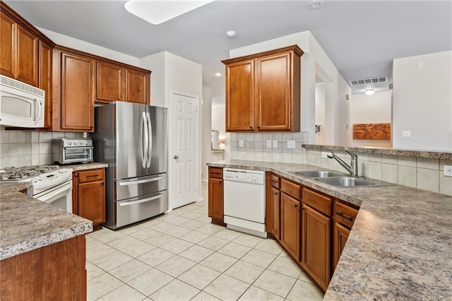 526 Moore Blvd, Covington, LA 70433 - kitchen featuring white appliances, a sink, decorative backsplash, and light tile patterned flooring
