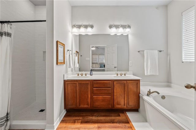 526 Moore Blvd, Covington, LA 70433 - full bathroom featuring a tile shower, a bath, double vanity, wood finished floors, and a ceiling fan