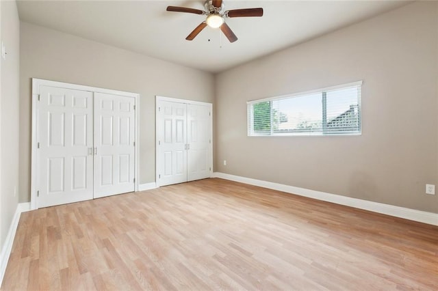 6409 Louis Xiv St, New Orleans, LA 70124 - unfurnished bedroom featuring multiple closets, light wood finished floors, baseboards, and a ceiling fan