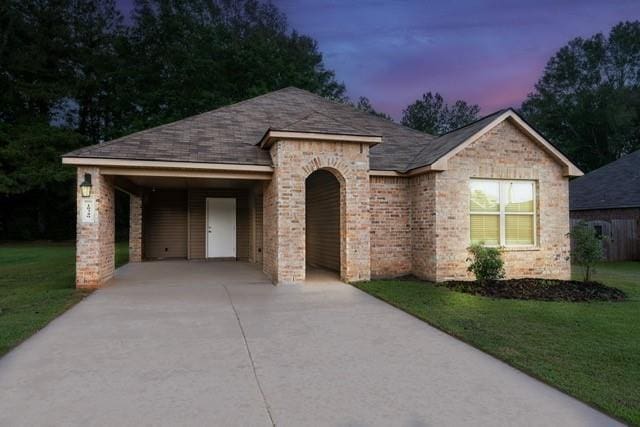 18349 Fox Hollow Loop, Hammond, LA 70401 - view of front of house with concrete driveway, a yard, brick siding, a shingled roof, and a carport