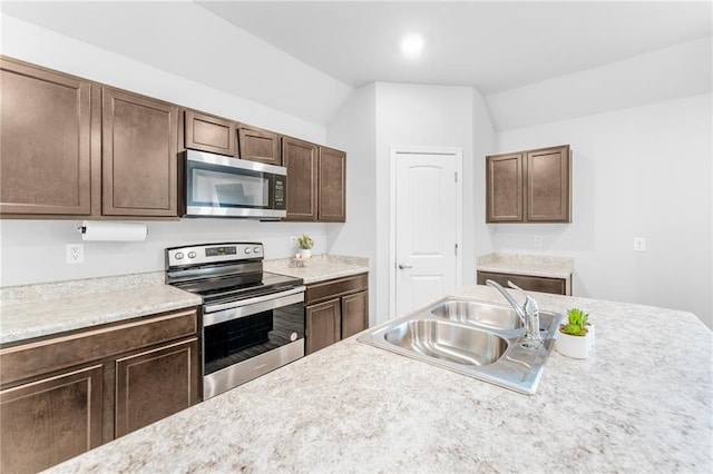 18349 Fox Hollow Loop, Hammond, LA 70401 - kitchen featuring appliances with stainless steel finishes, a sink, light countertops, lofted ceiling, and dark brown cabinetry