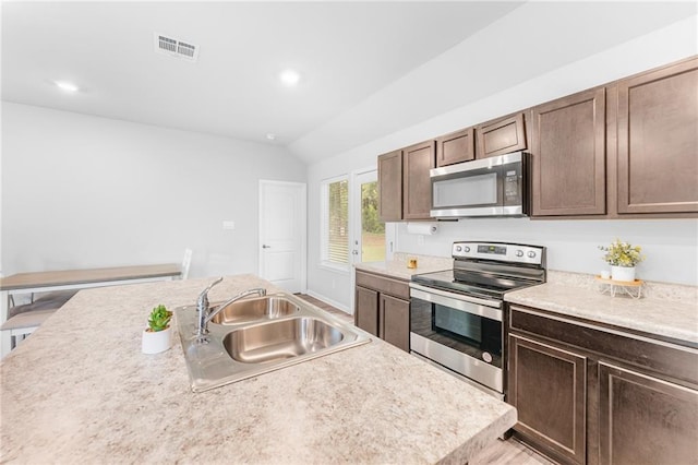 18349 Fox Hollow Loop, Hammond, LA 70401 - kitchen featuring appliances with stainless steel finishes, a sink, lofted ceiling, light countertops, and dark brown cabinets