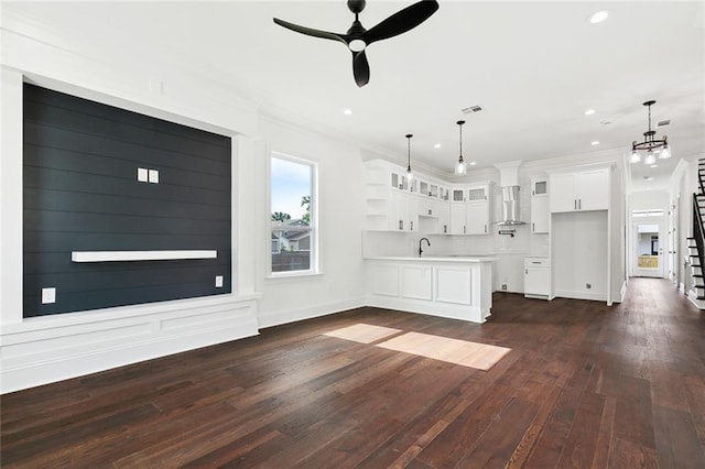 2824 Andover St, Jefferson, LA 70121 - unfurnished living room with ceiling fan, crown molding, dark wood-style floors, recessed lighting, and a chandelier