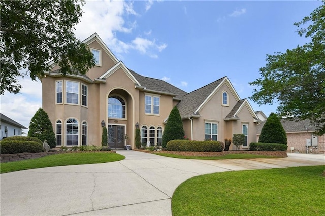 983 Lakeshore Blvd, Slidell, LA 70461 - traditional-style house with stucco siding, a front lawn, and curved driveway