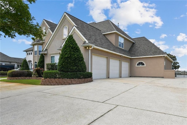 983 Lakeshore Blvd, Slidell, LA 70461 - view of home's exterior featuring stucco siding, driveway, a garage, and roof with shingles