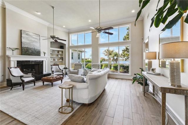 983 Lakeshore Blvd, Slidell, LA 70461 - living room with crown molding, a ceiling fan, wood finished floors, a tiled fireplace, and recessed lighting