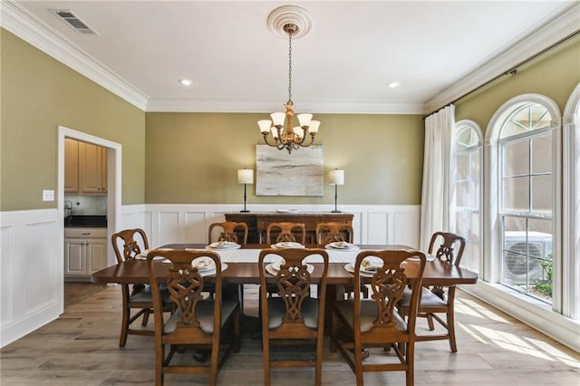 983 Lakeshore Blvd, Slidell, LA 70461 - dining area featuring healthy amount of natural light, a chandelier, a decorative wall, crown molding, and a wainscoted wall