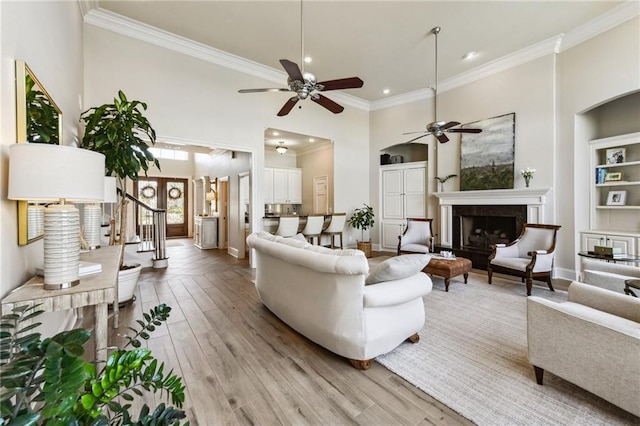 983 Lakeshore Blvd, Slidell, LA 70461 - living room with crown molding, ceiling fan, a towering ceiling, light wood-type flooring, and a fireplace