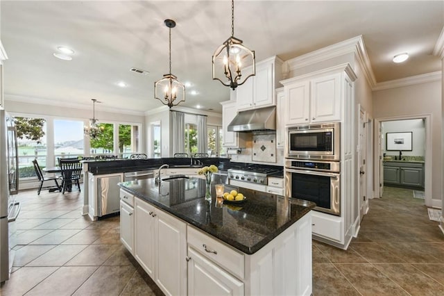 983 Lakeshore Blvd, Slidell, LA 70461 - kitchen featuring stainless steel appliances, under cabinet range hood, a chandelier, ornamental molding, and white cabinets