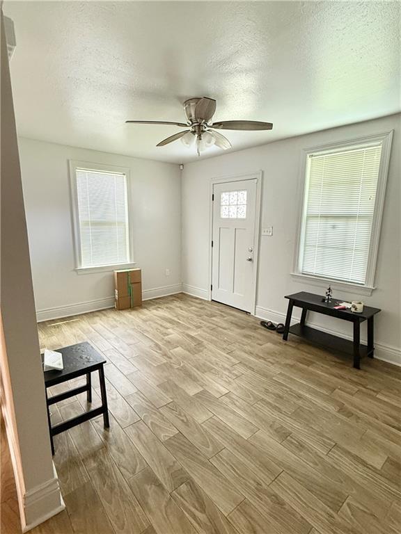 2012 Walkers Ln, Meraux, LA 70075 - entryway with a textured ceiling, ceiling fan, light wood-type flooring, and baseboards