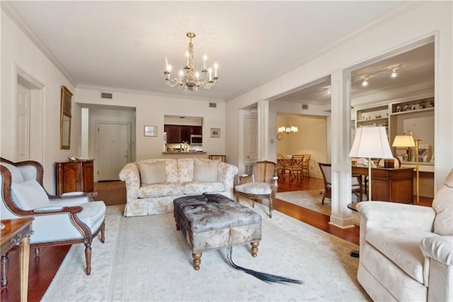 801 Rue Burgundy St Unit 113, Metairie, LA 70005 - living room featuring a chandelier, crown molding, and wood finished floors