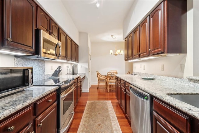 801 Rue Burgundy St Unit 113, Metairie, LA 70005 - kitchen featuring appliances with stainless steel finishes, dark wood-style floors, decorative backsplash, and light stone counters