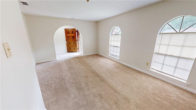 4813 Lake Como Ave, Metairie, LA 70006 - empty room with light colored carpet, arched walkways, a textured ceiling, and baseboards