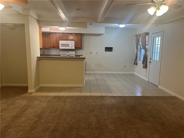 4813 Lake Como Ave, Metairie, LA 70006 - kitchen with white microwave, ceiling fan, dark countertops, light tile patterned floors, and beam ceiling