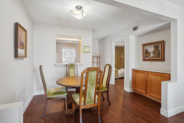 3320 N Arnoult Rd Unit 231, Metairie, LA 70002 - dining space with a textured ceiling, dark wood-style floors, and baseboards