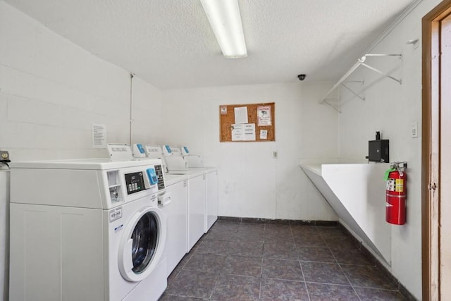 3320 N Arnoult Rd Unit 231, Metairie, LA 70002 - communal laundry room with washer and dryer, a textured ceiling, and baseboards