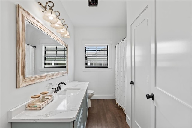 7599 Park Ave, Houma, LA 70364 - bathroom featuring toilet, vanity, wood finished floors, and baseboards