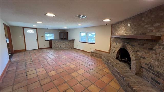 2008 Bluebird St, Slidell, LA 70460 - unfurnished living room featuring a brick fireplace, baseboards, tile patterned flooring, and recessed lighting
