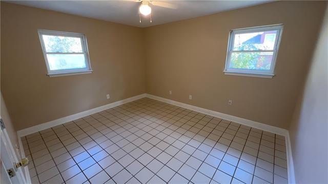 2008 Bluebird St, Slidell, LA 70460 - unfurnished room with plenty of natural light, ceiling fan, light tile patterned floors, and baseboards