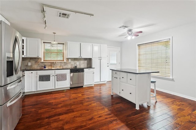 19196 Wildoak Ln, Ponchatoula, LA 70454 - kitchen featuring stainless steel appliances, dark countertops, decorative backsplash, and a kitchen bar