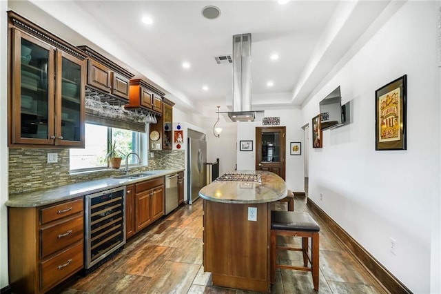 439 S Clark St, New Orleans, LA 70119 - kitchen with wine cooler, a sink, appliances with stainless steel finishes, decorative backsplash, and a center island
