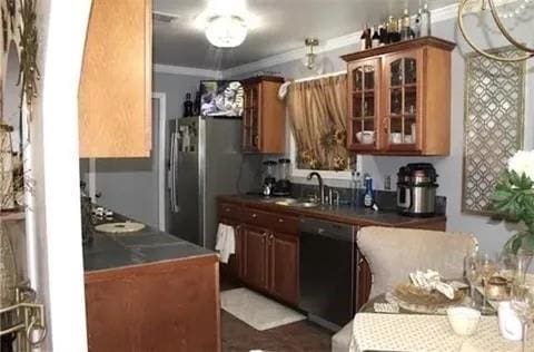 7522 Adventure Ave, New Orleans, LA 70129 - kitchen with dishwashing machine, crown molding, glass insert cabinets, brown cabinets, and freestanding refrigerator