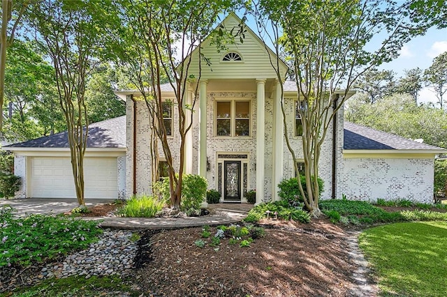 511 Beau Chene Dr, Mandeville, LA 70471 - neoclassical / greek revival house with a garage, concrete driveway, roof with shingles, and brick siding