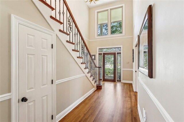511 Beau Chene Dr, Mandeville, LA 70471 - foyer entrance with baseboards, wood finished floors, stairway, a high ceiling, and a chandelier