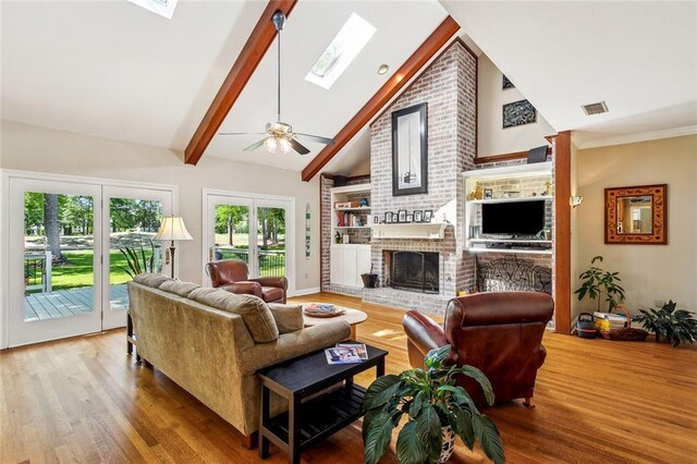 511 Beau Chene Dr, Mandeville, LA 70471 - living room featuring a skylight, a fireplace, wood finished floors, and healthy amount of natural light