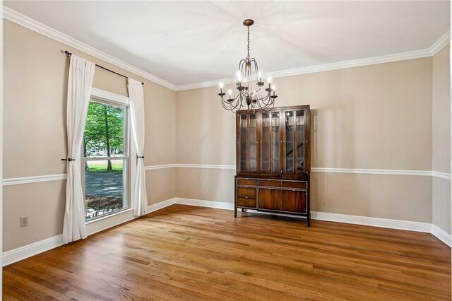 511 Beau Chene Dr, Mandeville, LA 70471 - spare room featuring a chandelier, wood finished floors, baseboards, and crown molding