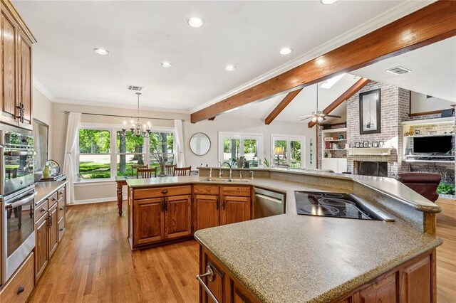 511 Beau Chene Dr, Mandeville, LA 70471 - kitchen featuring stainless steel appliances, a sink, a chandelier, a fireplace, and open floor plan