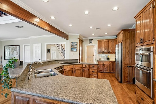 511 Beau Chene Dr, Mandeville, LA 70471 - kitchen with a sink, stainless steel appliances, recessed lighting, a spacious island, and light wood-type flooring