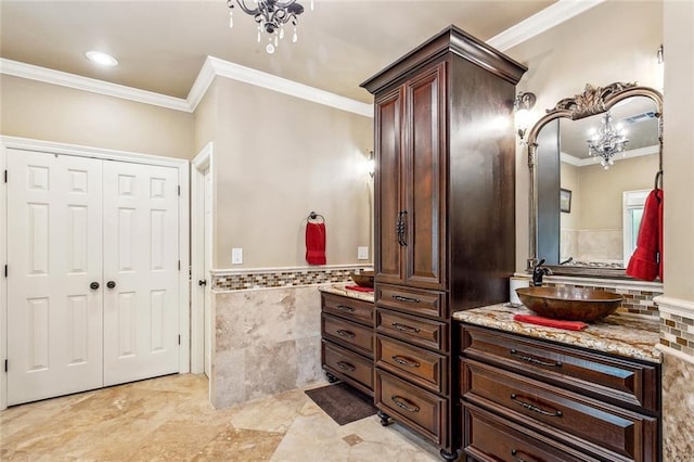 511 Beau Chene Dr, Mandeville, LA 70471 - full bath featuring a chandelier, tile walls, crown molding, vanity, and a wainscoted wall