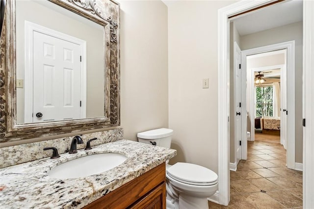 511 Beau Chene Dr, Mandeville, LA 70471 - bathroom featuring vanity, baseboards, toilet, tile patterned floors, and a ceiling fan